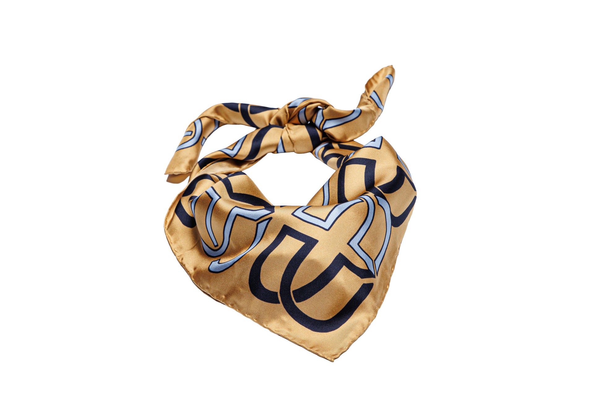 A square silk scarf with a gold base, featuring a bold black and light blue geometric pattern, tied in a knot on a plain white background.